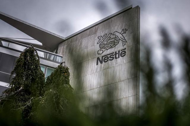 (FILES) This photograph shows the logo of Swiss food giant Nestle on the facade of its headquarters ahead of the companys third-quarter results announcement, in Vevey, western Switzerland, on October 14, 2025. Several NGOs said on October 30, 2025 they had filed a legal complaint in Germany accusing giant coffee companies of sourcing beans from suppliers that exploit workers and violate human rights. The complaint alleges that Nestle, Starbucks, Dallmayr and the Neumann Kaffee Gruppe (NKG) have all violated Germany's Supply Chain Act, which requires companies to monitor human rights and environmental issues throughout their global supply chains. (Photo by Fabrice COFFRINI / AFP)