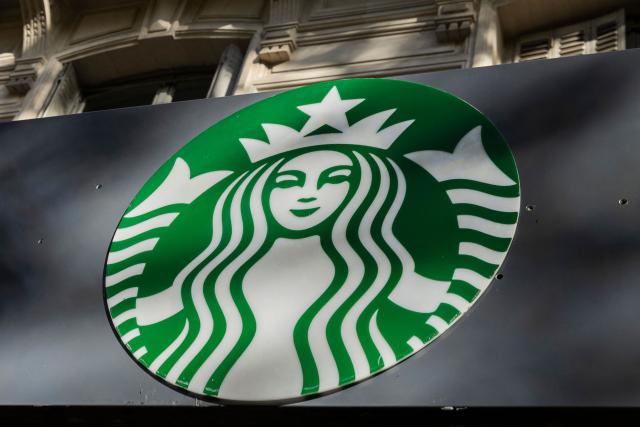 (FILES) This photograph shows the logo of US multinational company Starbucks on a building facade in Paris, on October 16, 2024. Several NGOs said on October 30, 2025 they had filed a legal complaint in Germany accusing giant coffee companies of sourcing beans from suppliers that exploit workers and violate human rights. The complaint alleges that Nestle, Starbucks, Dallmayr and the Neumann Kaffee Gruppe (NKG) have all violated Germany's Supply Chain Act, which requires companies to monitor human rights and environmental issues throughout their global supply chains. (Photo by Grégoire CAMPIONE / AFP)