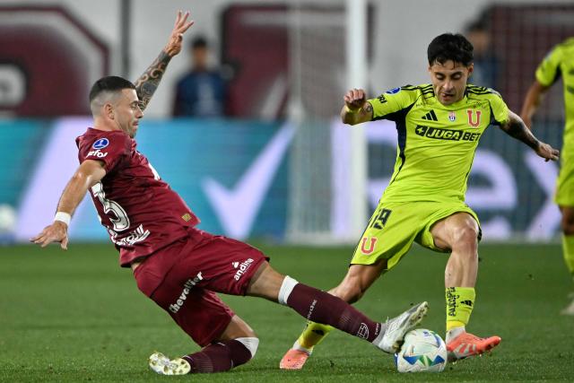 Lanus' midfielder #23 Ramiro Carrera and Universidad de Chile's midfielder #19 Javier Altamirano fight for the ball during the Copa Sudamericana semifinal second leg football match between Argentina's Lanus and Chile's Universidad de Chile at the Ciudad de Lanus stadium in Lanus, Buenos Aires province, on October 30, 2025. (Photo by Luis ROBAYO / AFP)