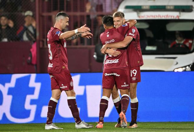 Lanus' midfielder #19 Rodrigo Castillo (R) celebrates scoring his team's first goal with teammates midfielder #11 Eduardo Salvio (C) and midfielder #23 Ramiro Carrera (L) during the Copa Sudamericana semifinal second leg football match between Argentina's Lanus and Chile's Universidad de Chile at the Ciudad de Lanus stadium in Lanus, Buenos Aires province, on October 30, 2025. (Photo by Luis ROBAYO / AFP)