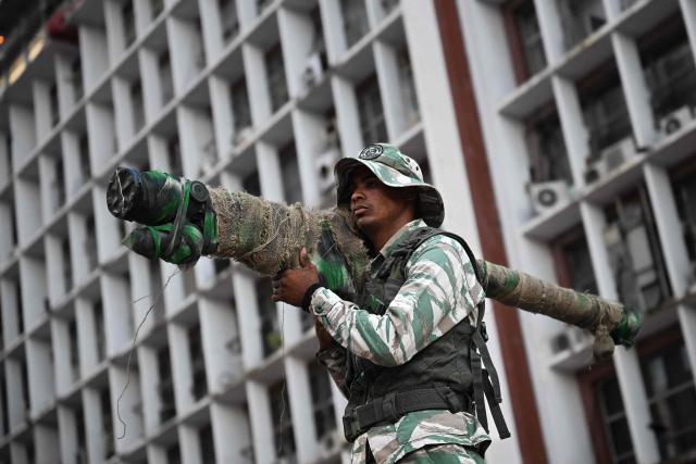 A member of the Bolivarian National Militia holds a Russian-made 9K338 "Igla-S" (SA-18) man-portable air-defense (MANPAD) surface-to-air missile launcher as he takes part in a rally against US military activity in the Caribbean, in Caracas on October 30, 2025. A US guided-missile destroyer that docked for four days in Trinidad and Tobago, within firing range of mainland Venezuela -- which called its presence a "provocation" -- departed as scheduled on Thursday, AFP witnessed. (Photo by Federico PARRA / AFP)