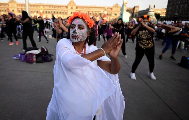 A woman with her face painted as a skull participates in a Mega Aerobic Dance class ahead of the Day of the Dead at the Zocalo Square in Mexico City on October 30, 2025. (Photo by Alfredo ESTRELLA / AFP)