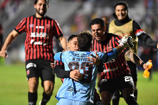 Alajuelense's Uruguayan goalkeeper #23 Washington Ortega (C) celebrates with teammates after winning the penalty shootout and the second leg of the CONCACAF Central American Cup semifinal football match between Honduras's Olimpia and Costa Rica's Alajuelense at the National Stadium Jose de la Paz Herrera in Tegucigalpa on October 30, 2025. (Photo by Orlando SIERRA / AFP)