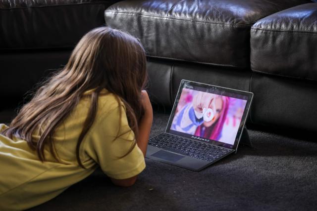 This photo taken on October 30, 2025 shows 10-year-old Bianca Navarro lying on the floor as she watches a show on YouTube at her home in western Sydney. Tech giants Meta and TikTok said on October 28 they will obey Australia's under-16 social media ban but warned the landmark laws could prove difficult to enforce. Australia will from December 10 force social media platforms such as Facebook, Instagram and TikTok to remove users under the age of 16. (Photo by David GRAY / AFP)