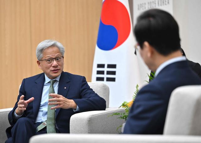 Nvidia founder and CEO Jensen Huang (L) talks with South Korean President Lee Jae Myung (R) during their meeting on the sidelines of the Asia-Pacific Economic Cooperation (APEC) summit in Gyeongju on October 31, 2025. (Photo by JUNG YEON-JE / POOL / AFP)