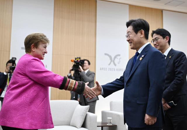 South Korean President Lee Jae Myung (R) shakes hands with International Monetary Fund (IMF) Managing Director Kristalina Georgieva (L) during their meeting on the sidelines of the Asia-Pacific Economic Cooperation (APEC) summit in Gyeongju on October 31, 2025. (Photo by JUNG YEON-JE / POOL / AFP)