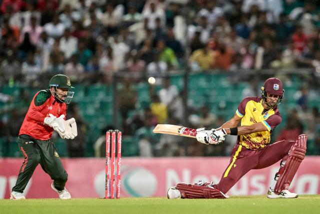 West Indies' captain Roston Chase (R) plays a shot as Bangladesh's captain Litton Das watches during the third Twenty20 international cricket match between Bangladesh and West Indies at the Bir Sreshtho Flight Lieutenant Matiur Rahman Stadium in Chittagong on October 31, 2025. (Photo by MUNIR UZ ZAMAN / AFP)