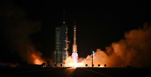 A Long March-2F carrier rocket, carrying the Shenzhou-21 spacecraft and a crew of three astronauts, lifts off from the Jiuquan Satellite Launch Centre in the Gobi desert, in northwest China on October 31, 2025. A new crew took off for China's Tiangong space station on October 31, including the country's youngest ever astronaut and four lab mice. (Photo by Hector RETAMAL / AFP)