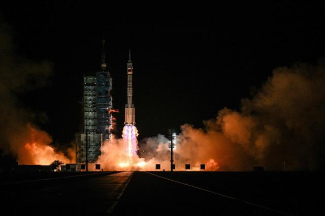 TOPSHOT - A Long March-2F carrier rocket, carrying the Shenzhou-21 spacecraft and a crew of three astronauts, lifts off from the Jiuquan Satellite Launch Centre in the Gobi desert, in northwest China on October 31, 2025. A new crew took off for China's Tiangong space station on October 31, including the country's youngest ever astronaut and four lab mice. (Photo by Hector RETAMAL / AFP)