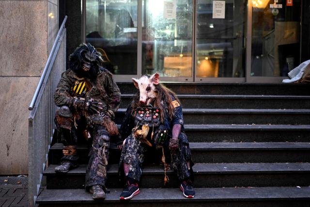Revellers wearing Halloween costumes sit on stairs on the sidelines of a Zombie Walk and Halloween celebrations in Essen, western Germany on October 31, 2025. (Photo by Ina FASSBENDER / AFP)