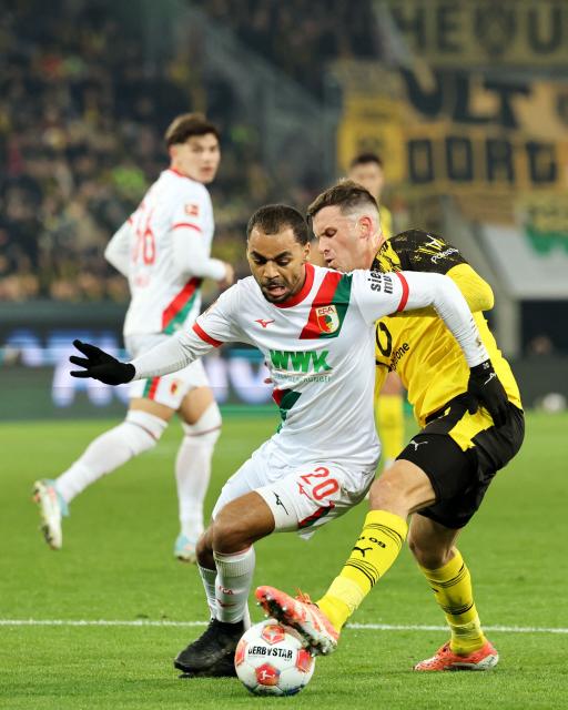 Augsburg's French midfielder #20 Alexis Claude-Maurice (L) and Dortmund's German midfielder #13 Pascal Gross vie for the ball during the German first division Bundesliga football match between FC Augsburg and Borussia Dortmund in Augsburg, southern Germany on October 31, 2025. (Photo by Alexandra BEIER / AFP) / DFL REGULATIONS PROHIBIT ANY USE OF PHOTOGRAPHS AS IMAGE SEQUENCES AND/OR QUASI-VIDEO