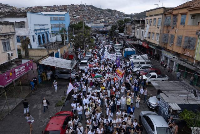 Aerial view of activists and residents taking part in a protest at the Penha Complex in Rio de Janeiro, Brazil, on October 31, 2025, to demand justice for victims of a massive police raid that left at least 117 suspected criminals and four police officers dead. (Photo by Pablo PORCIUNCULA / AFP)