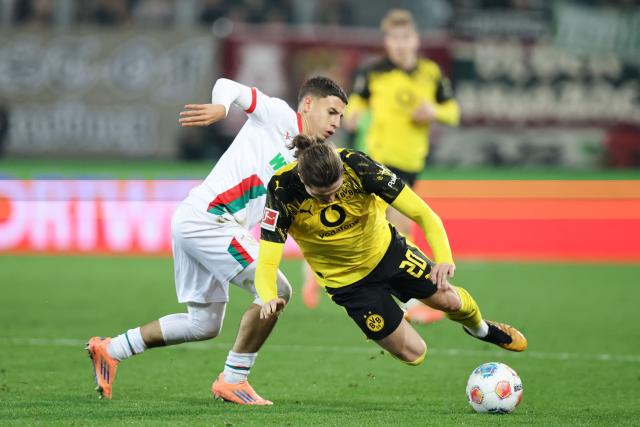 Dortmund's Austrian midfielder #20 Marcel Sabitzer (R) and Augsburg's Tunesian midfielder #11 Ismael Gharbi vie for the ball during the German first division Bundesliga football match between FC Augsburg and Borussia Dortmund in Augsburg, southern Germany on October 31, 2025. (Photo by Alexandra BEIER / AFP) / DFL REGULATIONS PROHIBIT ANY USE OF PHOTOGRAPHS AS IMAGE SEQUENCES AND/OR QUASI-VIDEO