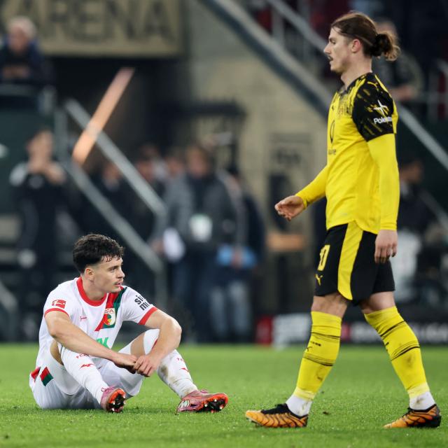 Augsburg's Swiss midfielder #32 Fabian Rieder (L) reacts next to Dortmund's Austrian midfielder #20 Marcel Sabitzer at the end of the German first division Bundesliga football match between FC Augsburg and Borussia Dortmund in Augsburg, southern Germany on October 31, 2025. Dortmund won the match 1-0. (Photo by Alexandra BEIER / AFP) / DFL REGULATIONS PROHIBIT ANY USE OF PHOTOGRAPHS AS IMAGE SEQUENCES AND/OR QUASI-VIDEO