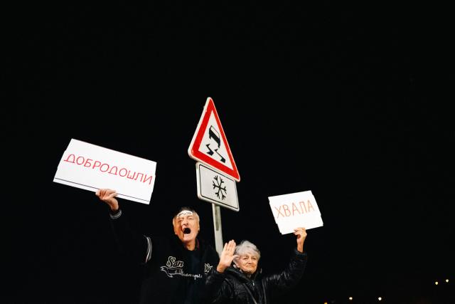 Attendees react as they greet a large group of student-protestors from the southern-Serbian city of Novi Pazar upon their arrival in Novi Sad after a 16-day march to take part in a gathering marking the first anniversary of the Novi Sad railway station tragedy, in Novi Sad, on October 31, 2025. The collapse of a railway station's canopy in Serbia's second-largest city on November 1, 2024, which killed 16 people just months after renovation, became a symbol of entrenched corruption and triggered huge demonstrations, bringing hundreds of thousands to the streets under the "bloody hand" stencil that became its emblem. (Photo by UROS ARSIC / AFP)