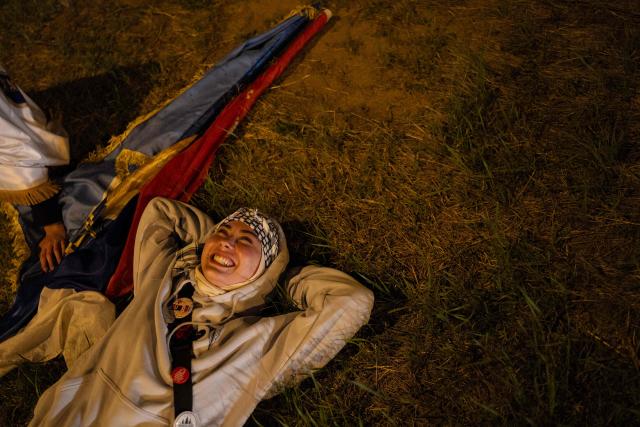 A student part of a large group of student-protestors from the southern-Serbian city of Novi Pazar reacts upon their arrival in Novi Sad after a 16-day march to take part in a gathering marking the first anniversary of the Novi Sad railway station tragedy, in Novi Sad, on October 31, 2025. The collapse of a railway station's canopy in Serbia's second-largest city on November 1, 2024, which killed 16 people just months after renovation, became a symbol of entrenched corruption and triggered huge demonstrations, bringing hundreds of thousands to the streets under the "bloody hand" stencil that became its emblem. (Photo by UROS ARSIC / AFP)