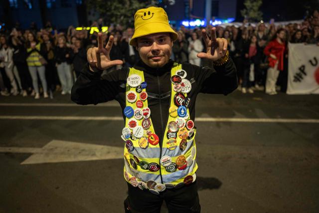 A student poses for a photo as fellow students from across Serbia arrive to the city of Novi Sad for a demonstration on October 31, 2025, on the eve of the first anniversary of a fatal railway station collapse that triggered mass protests. The collapse of a railway station's canopy in Serbia's second-largest city on November 1, 2024, which killed 16 people just months after renovation, became a symbol of entrenched corruption and triggered huge demonstrations, bringing hundreds of thousands to the streets under the "bloody hand" stencil that became its emblem. (Photo by Andrej ISAKOVIC / AFP)