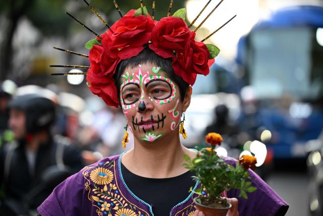 A woman with her face painted as "Catrina" participates in a protest march to demand the clarification of femicides in the context of the Day of the Dead celebrations in Mexico City on October 31, 2025. (Photo by Yuri CORTEZ / AFP)