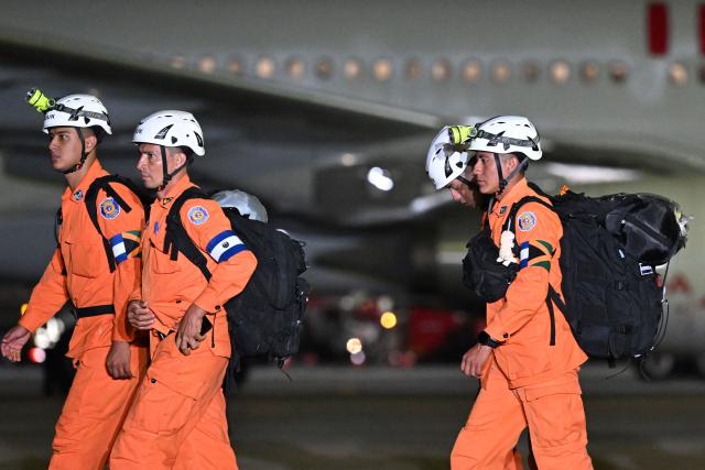 Members of the General Directorate of Civil Protection of El Salvador (DGPC) walk to board a plane with humanitarian aid bound for Jamaica, ordered by El Salvador's President Nayib Bukele, after the passage of Hurricane Melissa, at the tarmac of San Oscar Romero International Airport in San Luis Talpa, El Salvador on October 31, 2025. Melissa, the worst Atlantic hurricane in nearly a century, left at least 30 dead in Haiti and 19 in Jamaica, as well as parts of Cuba in ruins, as it moved through the Caribbean toward Bermuda on Thursday. (Photo by Marvin RECINOS / AFP)