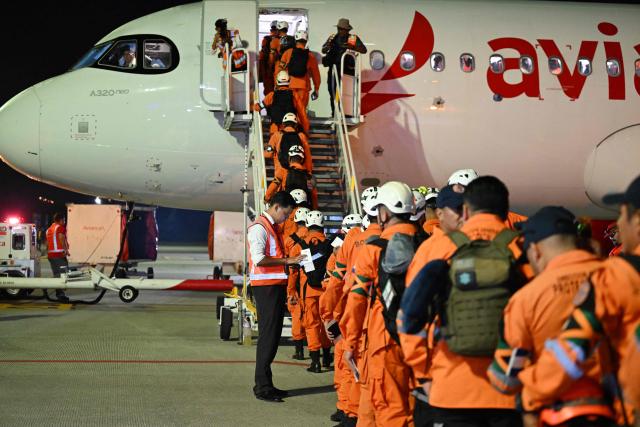 Members of the General Directorate of Civil Protection of El Salvador (DGPC) board a plane with humanitarian aid bound for Jamaica, ordered by El Salvador's President Nayib Bukele, after the passage of Hurricane Melissa, at the tarmac of San Oscar Romero International Airport in San Luis Talpa, El Salvador on October 31, 2025. Melissa, the worst Atlantic hurricane in nearly a century, left at least 30 dead in Haiti and 19 in Jamaica, as well as parts of Cuba in ruins, as it moved through the Caribbean toward Bermuda on Thursday. (Photo by Marvin RECINOS / AFP)