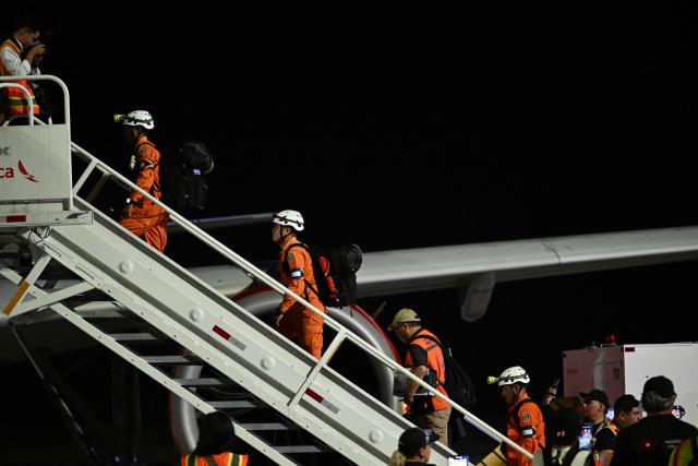 Members of the General Directorate of Civil Protection of El Salvador (DGPC) board a plane with humanitarian aid bound for Jamaica, ordered by El Salvador's President Nayib Bukele, after the passage of Hurricane Melissa, at the tarmac of San Oscar Romero International Airport in San Luis Talpa, El Salvador on October 31, 2025. Melissa, the worst Atlantic hurricane in nearly a century, left at least 30 dead in Haiti and 19 in Jamaica, as well as parts of Cuba in ruins, as it moved through the Caribbean toward Bermuda on Thursday. (Photo by Marvin RECINOS / AFP)
