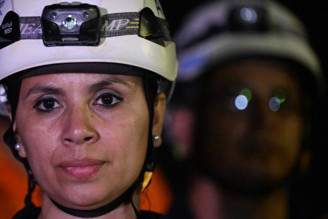 A member of the General Directorate of Civil Protection of El Salvador (DGPC) looks on as she prepares to board a plane with humanitarian aid bound for Jamaica, ordered by El Salvador's President Nayib Bukele, after the passage of Hurricane Melissa, at the tarmac of San Oscar Romero International Airport in San Luis Talpa, El Salvador on October 31, 2025. Melissa, the worst Atlantic hurricane in nearly a century, left at least 30 dead in Haiti and 19 in Jamaica, as well as parts of Cuba in ruins, as it moved through the Caribbean toward Bermuda on Thursday. (Photo by Marvin RECINOS / AFP)