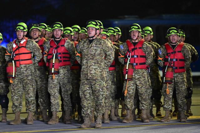 Salvadorean soldiers stand in formation as they prepare to board a plane with humanitarian aid bound for Jamaica, ordered by El Salvador's President Nayib Bukele, after the passage of Hurricane Melissa, at the tarmac of San Oscar Romero International Airport in San Luis Talpa, El Salvador on October 31, 2025. Melissa, the worst Atlantic hurricane in nearly a century, left at least 30 dead in Haiti and 19 in Jamaica, as well as parts of Cuba in ruins, as it moved through the Caribbean toward Bermuda on Thursday. (Photo by Marvin RECINOS / AFP)