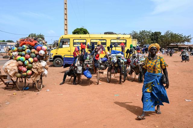 Street vendors gather in street in Tengrela, northern Ivory Coast near the Mali border, on October 31, 2025. (Photo by Issouf SANOGO / AFP)