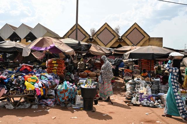 Customers shop at a market in Tengrela, northern Ivory Coast near the Mali border, on October 31, 2025. (Photo by Issouf SANOGO / AFP)
