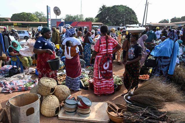 Customers shop at a market in Tengrela, northern Ivory Coast near the Mali border, on October 31, 2025. (Photo by Issouf SANOGO / AFP)