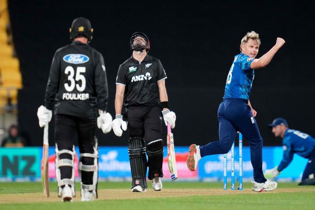 New Zealand's Daryl Mitchell (C) reacts to being caught as England's Sam Curran (R) celebrates during the third one-day international (ODI) cricket match between New Zealand and England at Sky Stadium in Wellington on November 1, 2025. (Photo by Marty MELVILLE / AFP)
