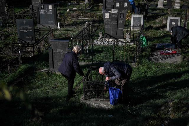Kosovo Serbs visit the graves of their relatives on All Souls' Day at the Orthodox cemetery in the ethnically divided Kosovo town of Mitrovica on November 1, 2025. Serbs from the north part of Mitrovica cross the river into the mainly Albanian Muslim south to pay respects to their lost ones during "Zadusnice," the Serbian Orthodox equivalent of "All Souls'Day ," at the Orthodox graveyard, which was vandalized during the 1998-1999 war. (Photo by Armend NIMANI / AFP)