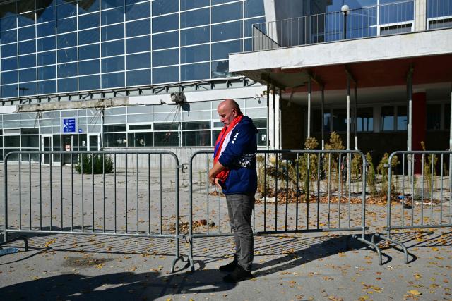 A mourner stands outside the station during a gathering marking the first anniversary of the Novi Sad railway station tragedy, in Novi Sad, on November 1, 2025. Tens of thousands gather in Serbia's second largest city Novi Sad to commemorate victims of a railway station collapse a year ago that triggered mass protests. On November 1, 2024, the collapse of the canopy at the newly-renovated railway station in Novi Sad killed 16 people. Regular student-led protests have gripped the Balkan nation since the tragedy, which became a symbol of entrenched corruption. (Photo by Andrej ISAKOVIC / AFP)