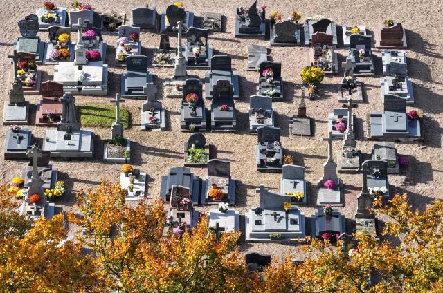 This aerial photograph shows graves decorated with flowers on All Saints' Day in a cemetery in Hede-Bazouges, northwestern France on November 1, 2025. (Photo by Damien MEYER / AFP)