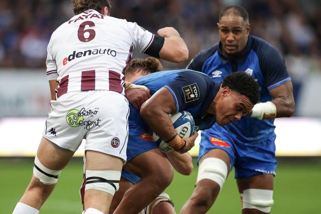 Castres' New Zealand number eight Feibyan Cornell Tukino (C) is tackled during the French Top 14 rugby union match between Castres Olympique and Union Bordeaux-Begles (UBB) at Stade Pierre Fabre in Castres, southern France on November 1, 2025. (Photo by Valentine CHAPUIS / AFP)