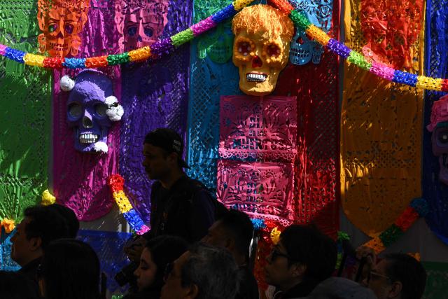 People attend a mass in memory of individuals buried as unknown in a mass grave at the Dolores Cemetery in Mexico City, on November 1, 2025, during an event organized by the National Search Commission (CNB), El Caracol A.C., and other civil society groups. (Photo by Yuri CORTEZ / AFP)