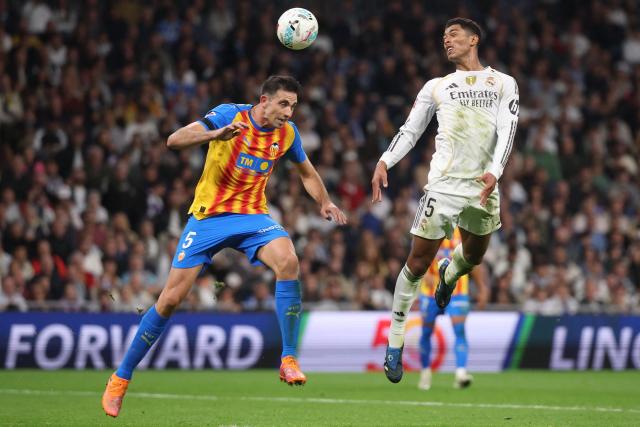 Valencia's Spanish defender # 05 Cesar Tarrega (L) and Real Madrid's English midfielder #05 Jude Bellingham vie for a header during the Spanish League football match between Real Madrid CF and Valencia CF at Santiago Bernabeu Stadium in Madrid on November 1, 2025. (Photo by Oscar DEL POZO / AFP)