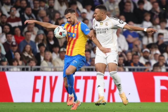 Valencia's Spanish defender # 03 Jose Copete and Real Madrid's French forward #10 Kylian Mbappe vie for the ball during the Spanish League football match between Real Madrid CF and Valencia CF at Santiago Bernabeu Stadium in Madrid on November 1, 2025. (Photo by Oscar DEL POZO / AFP)