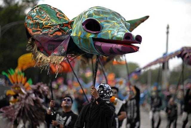 Revellers attend the Grand Parade commemorating the Day of the Dead in Mexico City, on November 1, 2025. (Photo by CARL DE SOUZA / AFP)