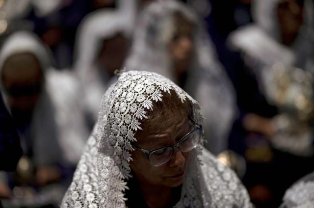 A Catholic faithful attends the traditional Lord of Miracles procession in Lima on November 1, 2025. (Photo by ERNESTO BENAVIDES / AFP)
