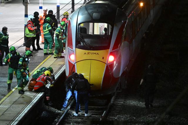 Police officers and members of the Emergency services search the track beneath an LNER Azuma train at Huntingdon Station in Huntingdon, eastern England, on November 1, 2025, following a stabbing on a train. UK police said they had arrested two suspects Saturday as "a number of people" were taken to hospital after a stabbing on a train in Cambridgeshire, eastern England. "We are currently responding to an incident on a train to Huntingdon where multiple people have been stabbed," British Transport Police said on X, adding that "two people have been arrested". (Photo by JUSTIN TALLIS / AFP)