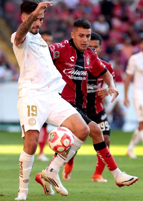 Toluca's Argentine midfielder #19 Santiago Simon and Atlas' Argentine midfielder #08 Mateo Garcia fight for the ball during the Liga MX Apertura football match between Atlas and Toluca at Jalisco Stadium in Guadalajara, Mexico on November 1, 2025. (Photo by Ulises Ruiz / AFP)