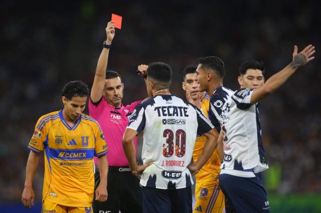 Mexican referee Cesar Ramos shows a red card to Monterrey's Argentine midfielder #30 Jorge Rodriguez during the Liga MX Apertura football tournament match between Monterrey and Tigres at BBVA Stadium in Monterrey, Mexico on November 1, 2025. (Photo by Julio Cesar AGUILAR / AFP)