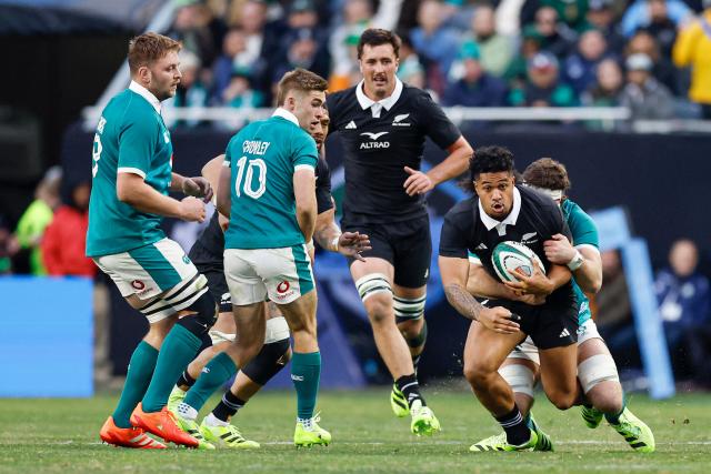 New Zealand's Leicester Fainga'anuku (22) is tackled by Ireland's Caelan Doris (20) during the second half of the "Gallagher Cup" international rugby test match at Soldier Field in Chicago, Illinois, on November 1, 2025. (Photo by KAMIL KRZACZYNSKI / AFP)