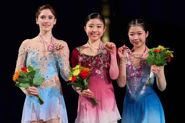 Gold medalist Mone Chiba of Japan (C) poses with silver medalist Isabeau Levito of the United States (L) and Ami Nakai of Japan during the victory ceremony for the women’s competition during the ISU Grand Prix of Figure Skating 2025 Skate Canada International at the SaskTel Centre in Saskatoon, Saskatchewan, Canada on November 1, 2025. (Photo by Geoff Robins / AFP)
