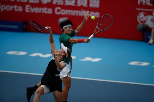 Momoko Kobori of Japan (front) and Peangtarn Plipuech of Thailand hit a return against Jiang Xinyu and Wang Yafan of China during the women's doubles final match in the Hong Kong Tennis Open in Hong Kong on November 2, 2025. (Photo by May James / AFP)