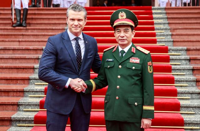 Vietnam's Defense Minister Phan Van Giang (R) and US Defense Secretary Pete Hegseth (L) shake hands during a welcoming ceremony at the Ministry of Defense headquarters in Hanoi on November 2, 2025. (Photo by AFP)