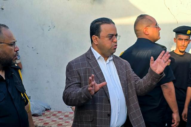 (FILES) Minister of labour in Libya's Tripoli-based administration Ali Al-Abed (C) checks the premises following a raid by an Anti-Illegal Immigration Agency force in an unregistered migrant housing unit in Tripoli early on July 26, 2025. Libyan prosecutors have announced  on November 2, 2025, that they are detaining the country's Education Minister Ali al-Abed for negligence over a scandal involving school textbooks. The 2025-2026 school year began over a month late in Libya, with the parents of nearly 2.6 million students who lacked books forced to shell out for photocopies. In Libyan public schools, textbooks are provided free of charge through the end of secondary school, paid for through a special allocation in the education ministry budget. (Photo by Mahmud Turkia / AFP)