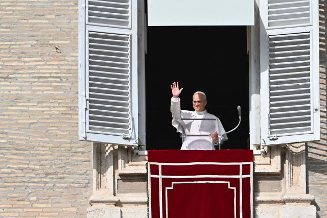 Pope Leo XIV waves to the crowd from the window of the apostolic palace overlooking St. Peter's square during the Angelus prayer in The Vatican on November 2, 2025. (Photo by Andreas SOLARO / AFP)