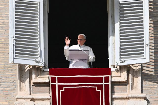 Pope Leo XIV blesses the crowd from the window of the apostolic palace overlooking St. Peter's square during the Angelus prayer in The Vatican on November 2, 2025. (Photo by Andreas SOLARO / AFP)